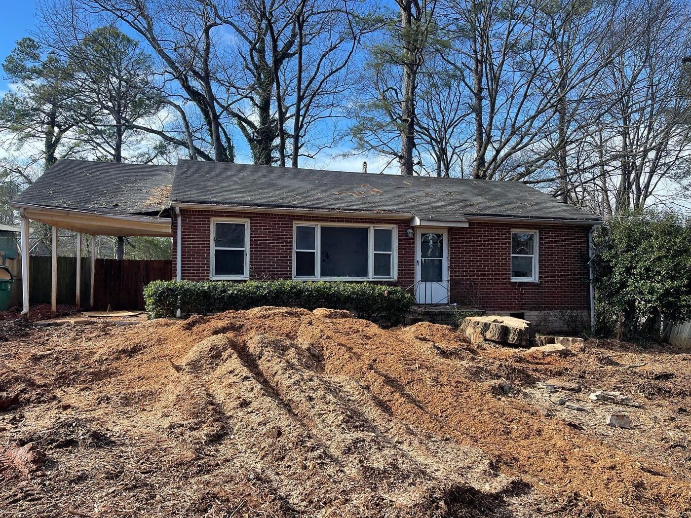 Finished front yard after grinding — level chip bed in front of the house
